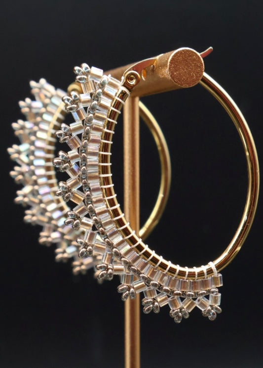 Gold and silver hoop earrings on a black background