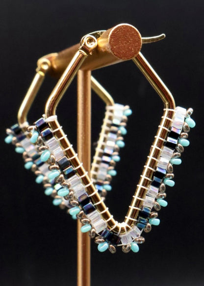 Beaded hoop earrings on a stand with a dark background