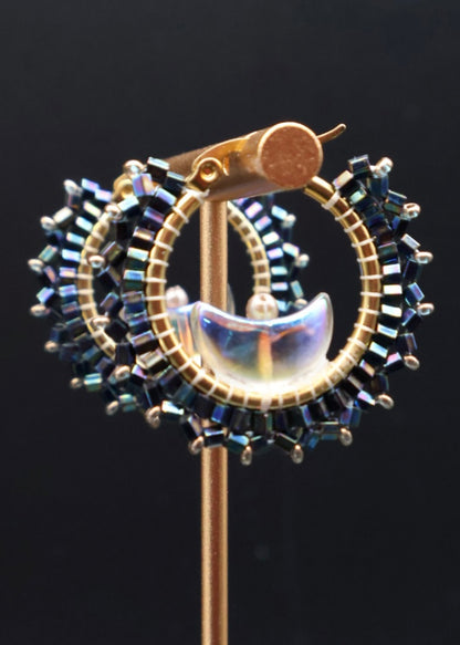 Decorative stickpin with gold, blue, and white elements on a black background