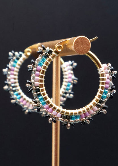 Hoop earrings with colorful beads on a black background