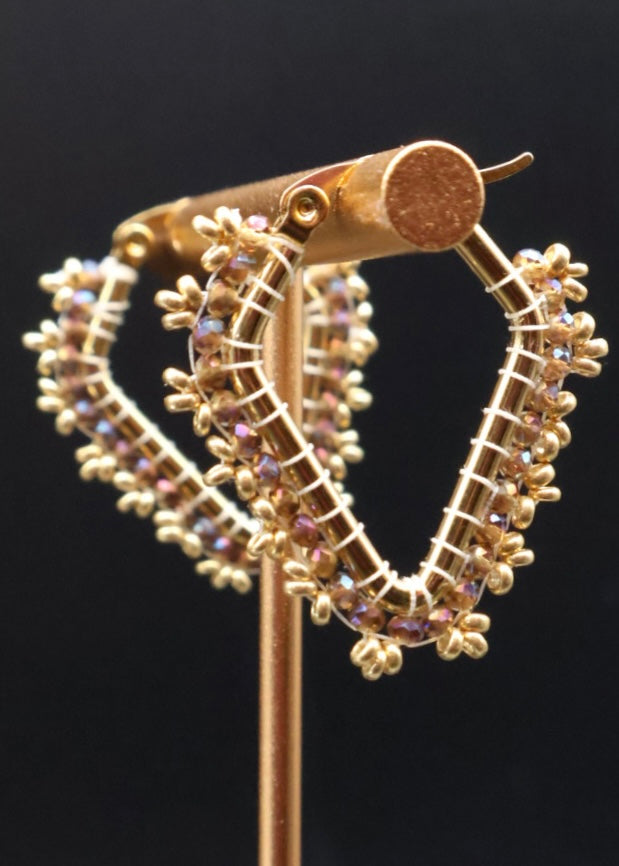 Gold hoop earrings with gemstones on a black background