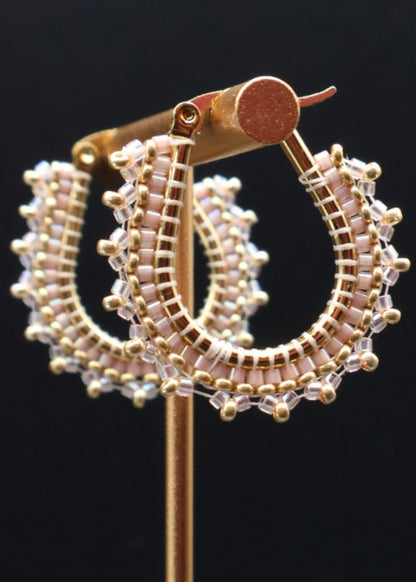 Gold hoop earrings with beaded design on a black background