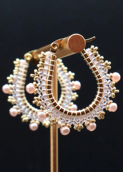 Gold and pearl earring on a black background