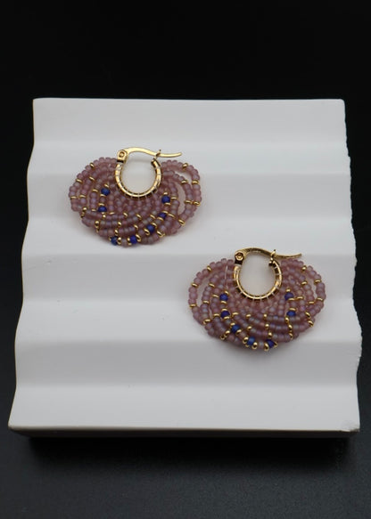 Pair of beaded earrings on a white stand with a black background