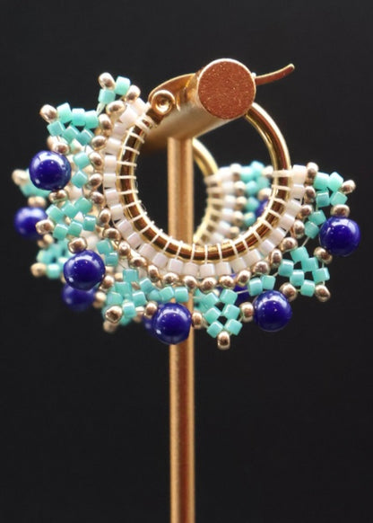 Decorative brooch with blue and gold design on a black background