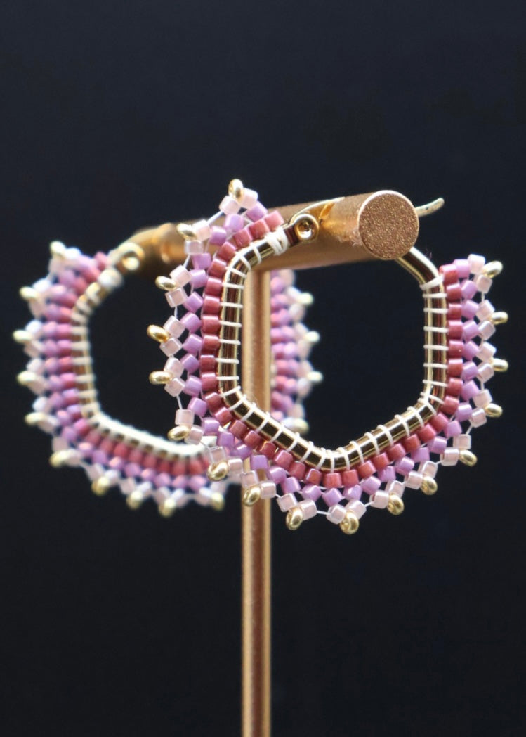 Pair of beaded hoop earrings on a black background