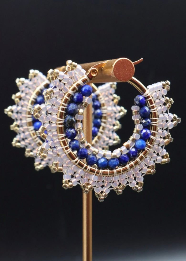 Gold, blue, and clear beaded earrings on a black background
