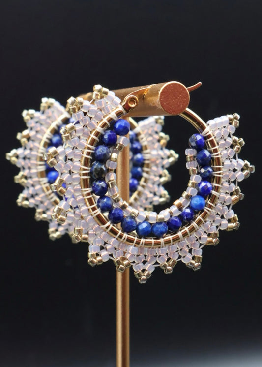 Gold, blue, and clear beaded earrings on a black background