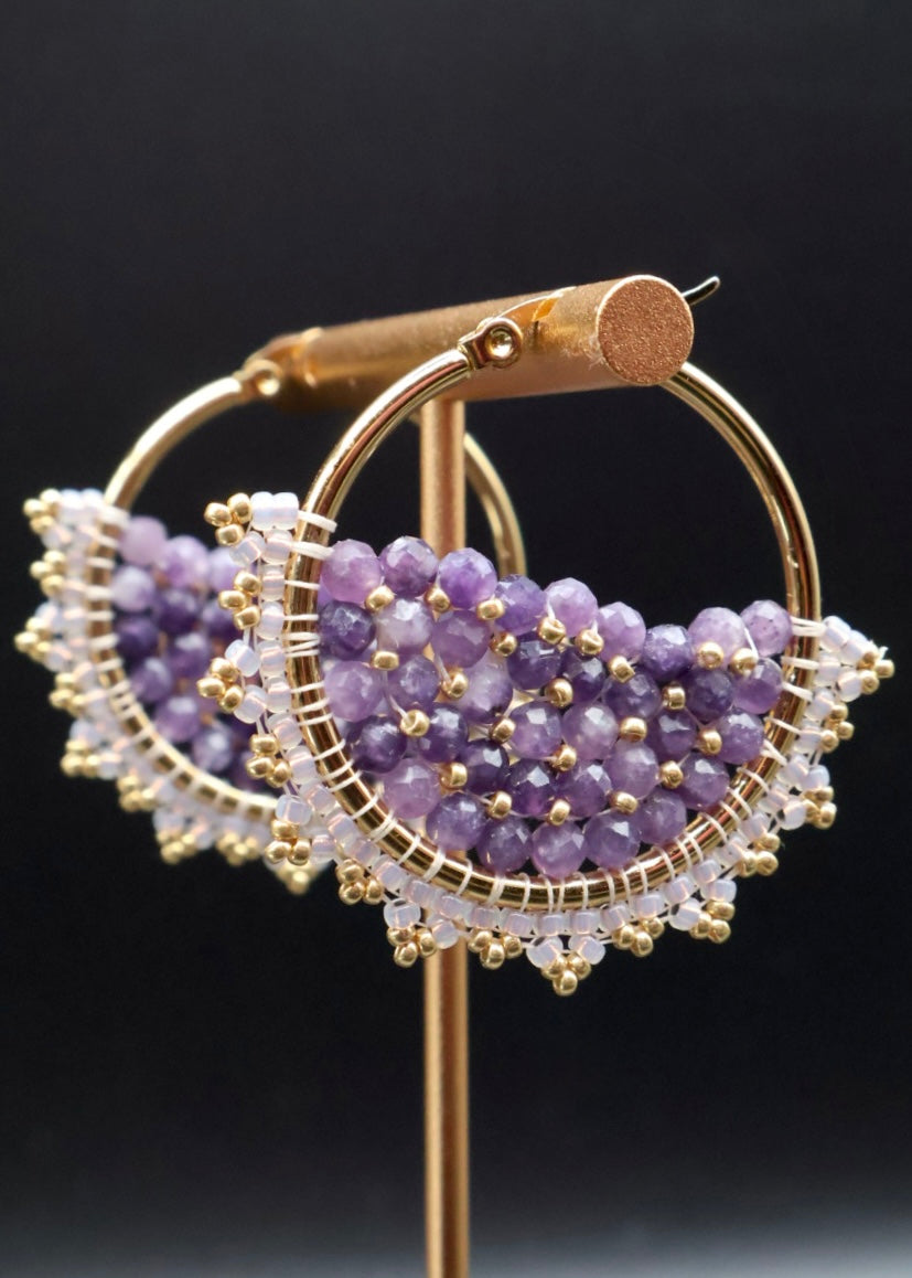 Gold and purple beaded earring on a black background
