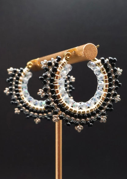 Pair of hoop earrings with black and clear beads on a black background