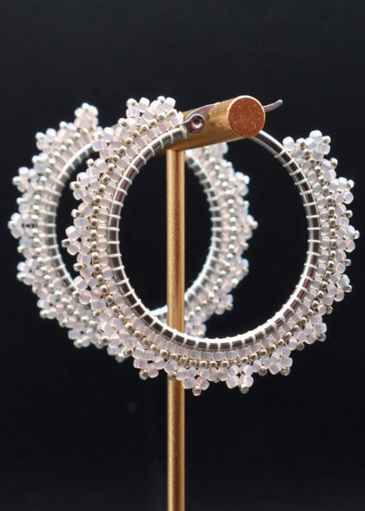 Pair of beaded hoop earrings on a black background