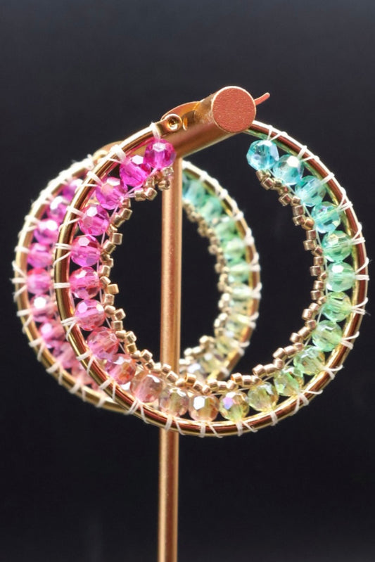 Multicolored gemstone hoop earrings on a black background