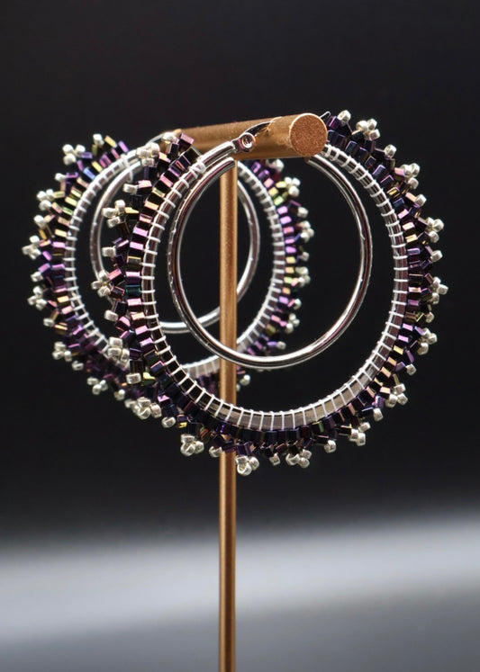 Decorative brooch with circular design and beaded details on a dark background