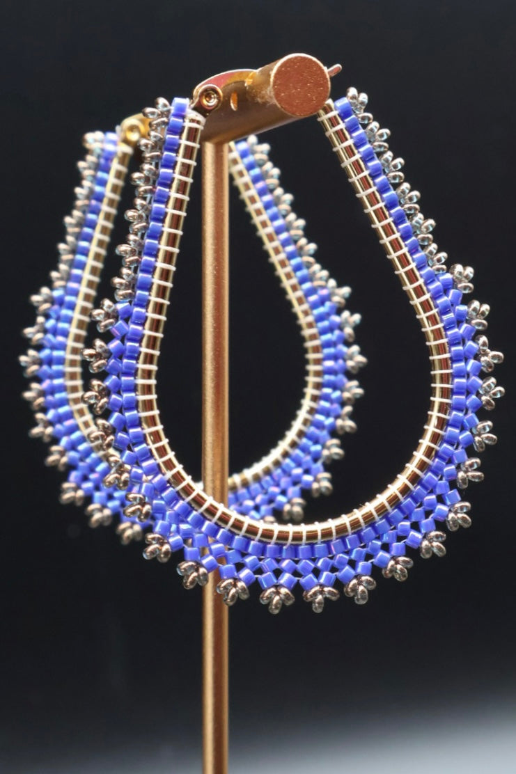 Blue beaded earrings on a black background