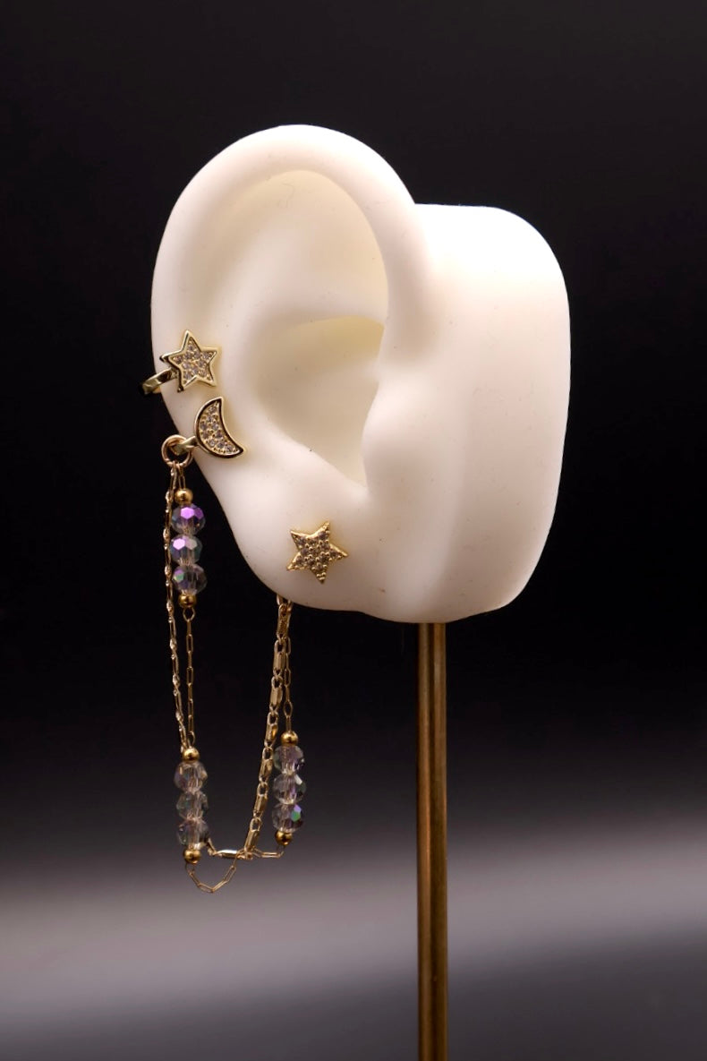 Earring displayed on a mannequin ear with a dark background