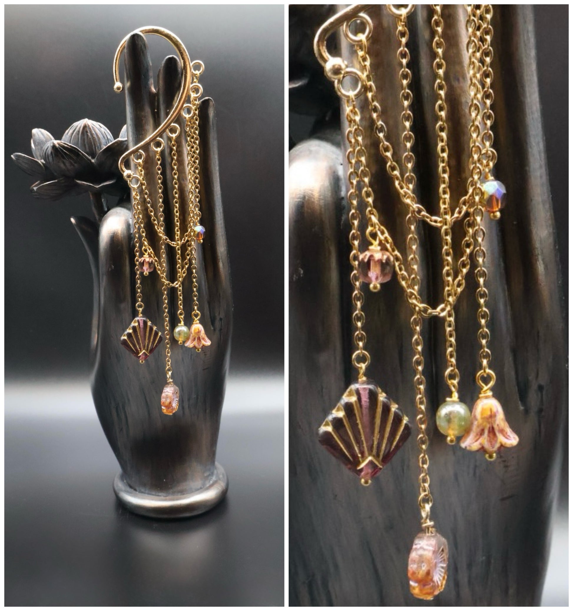 Gold chain earrings with various charms on a black hand-shaped stand.