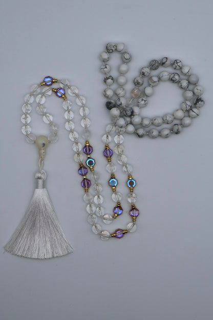 Two beaded necklaces with tassels on a gray background