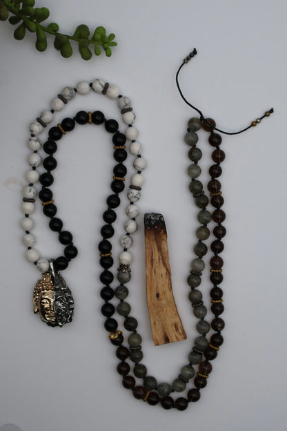 Two beaded necklaces with a wooden piece on a light gray background