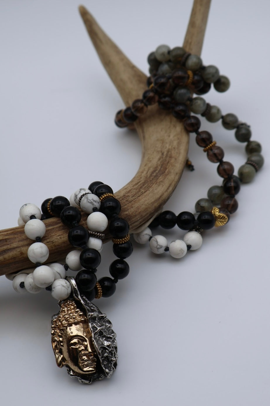 Necklace with beads and a Buddha charm on a white background