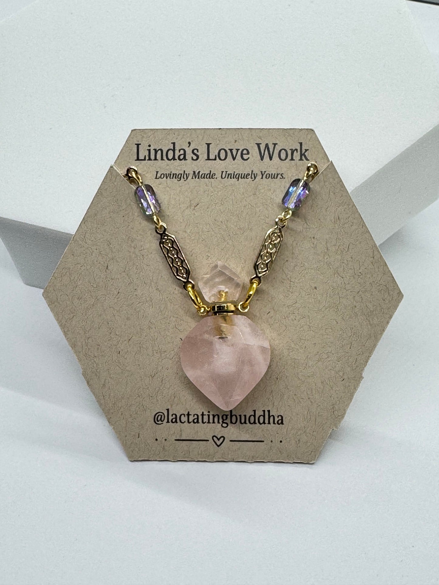Jewelry with pink stone and gold chain on a branded card