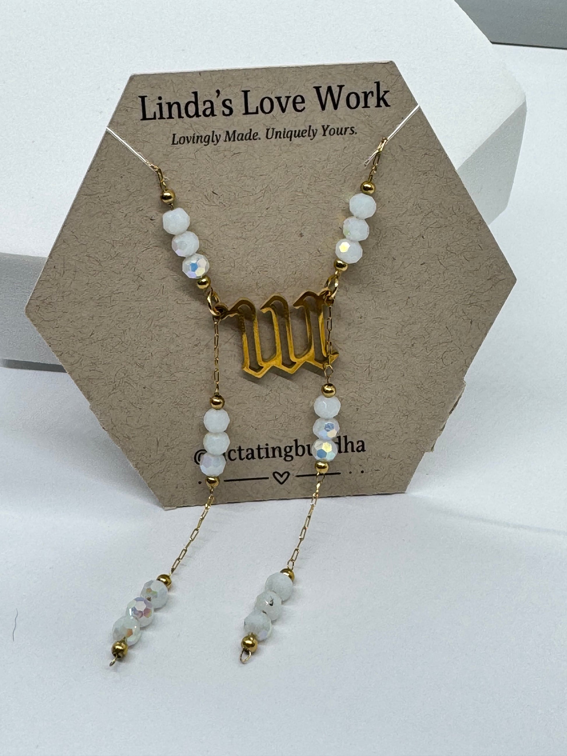Necklace with gold and white beads on a branded card