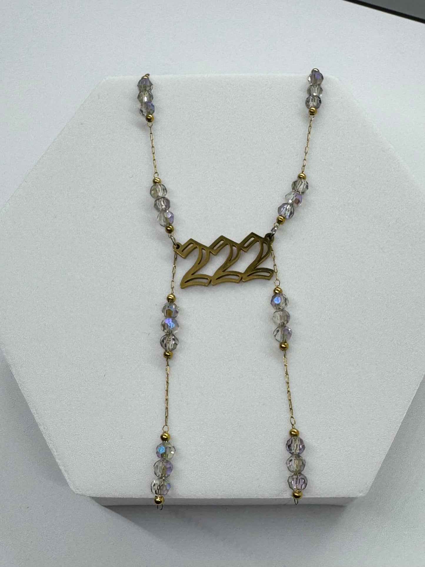 Necklace with '22' pendant on a white stand