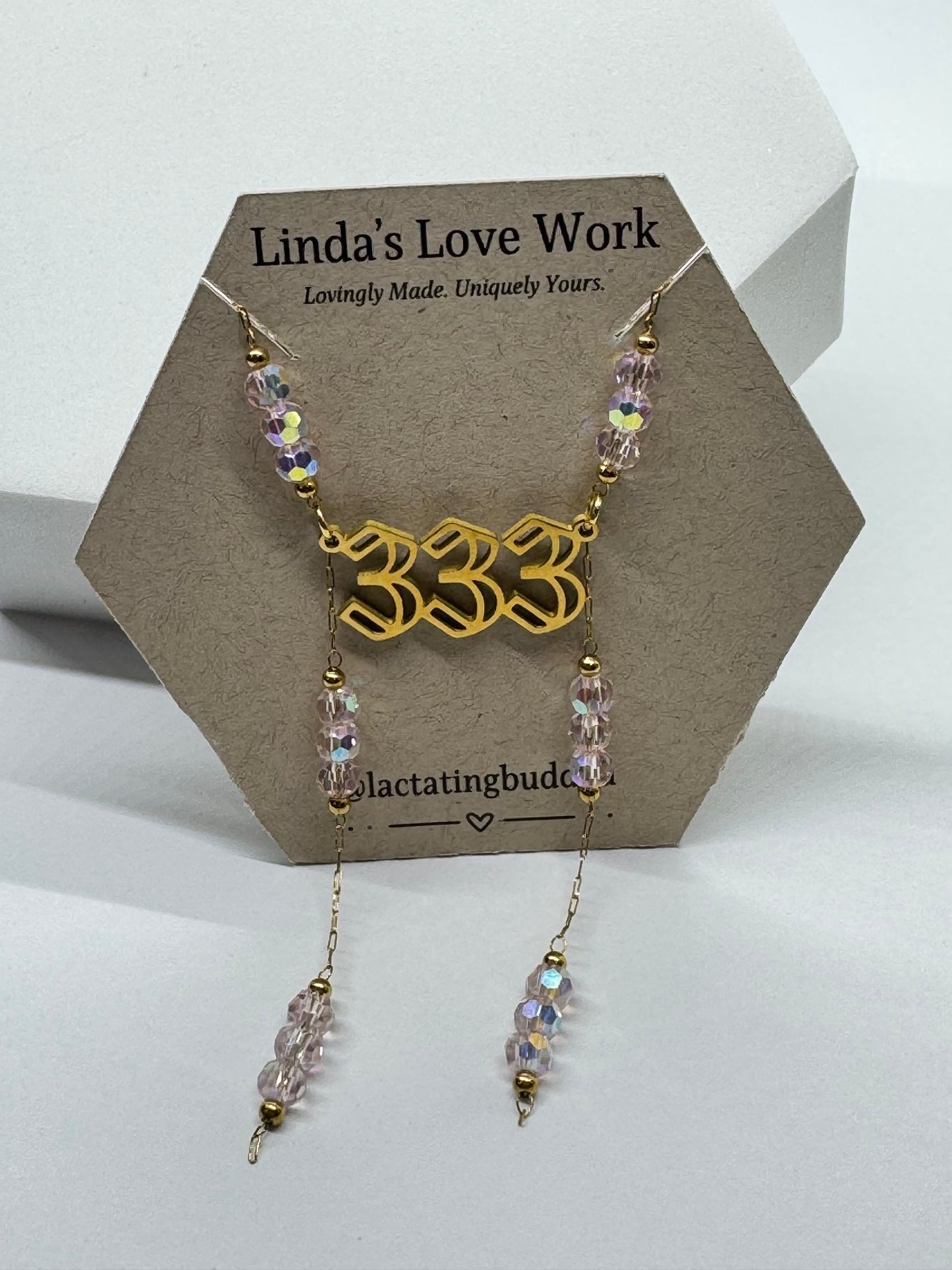 Necklace with beaded design on a branded card against a white background