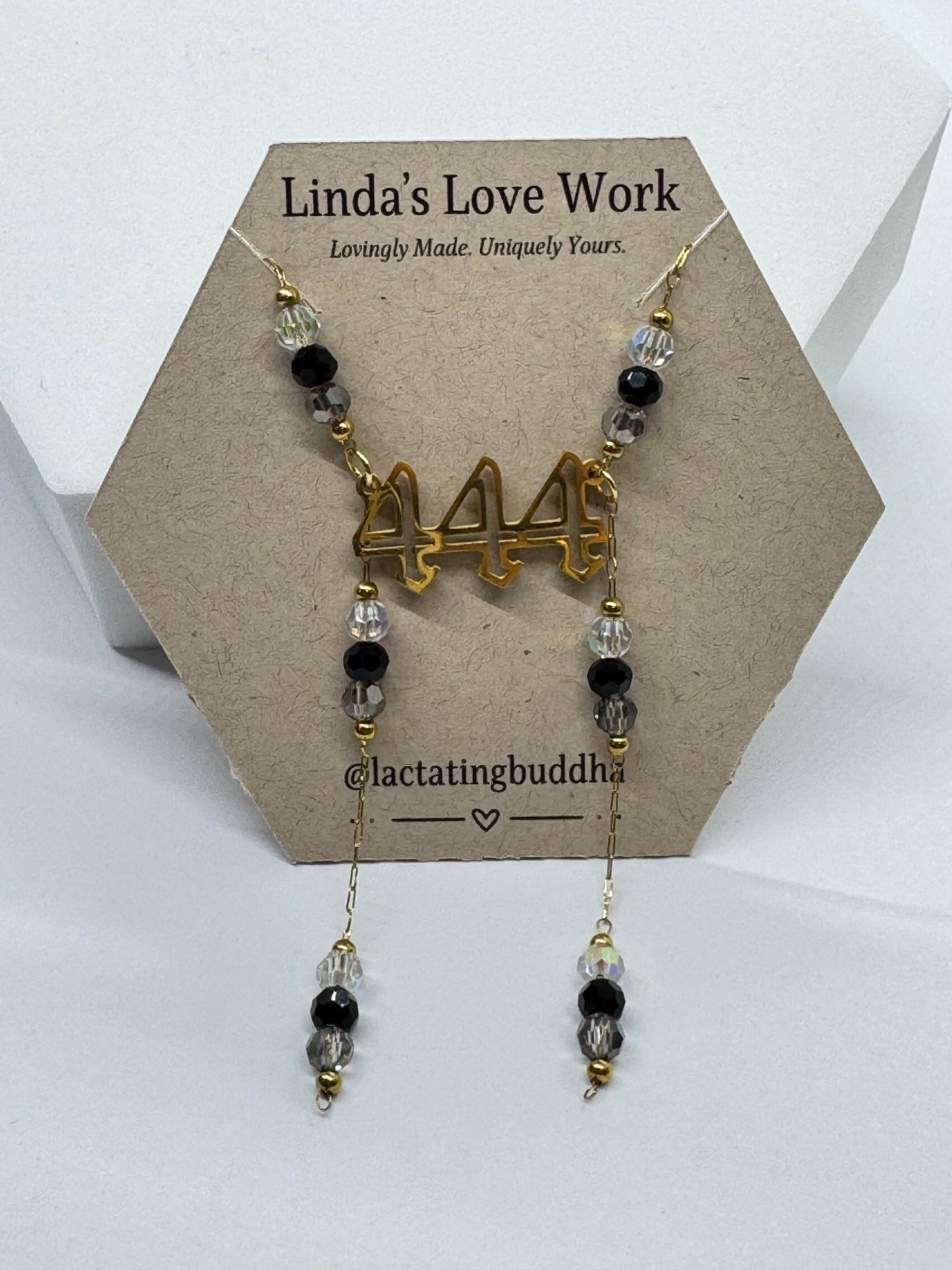 Necklace with beads and gold charm on a branded card