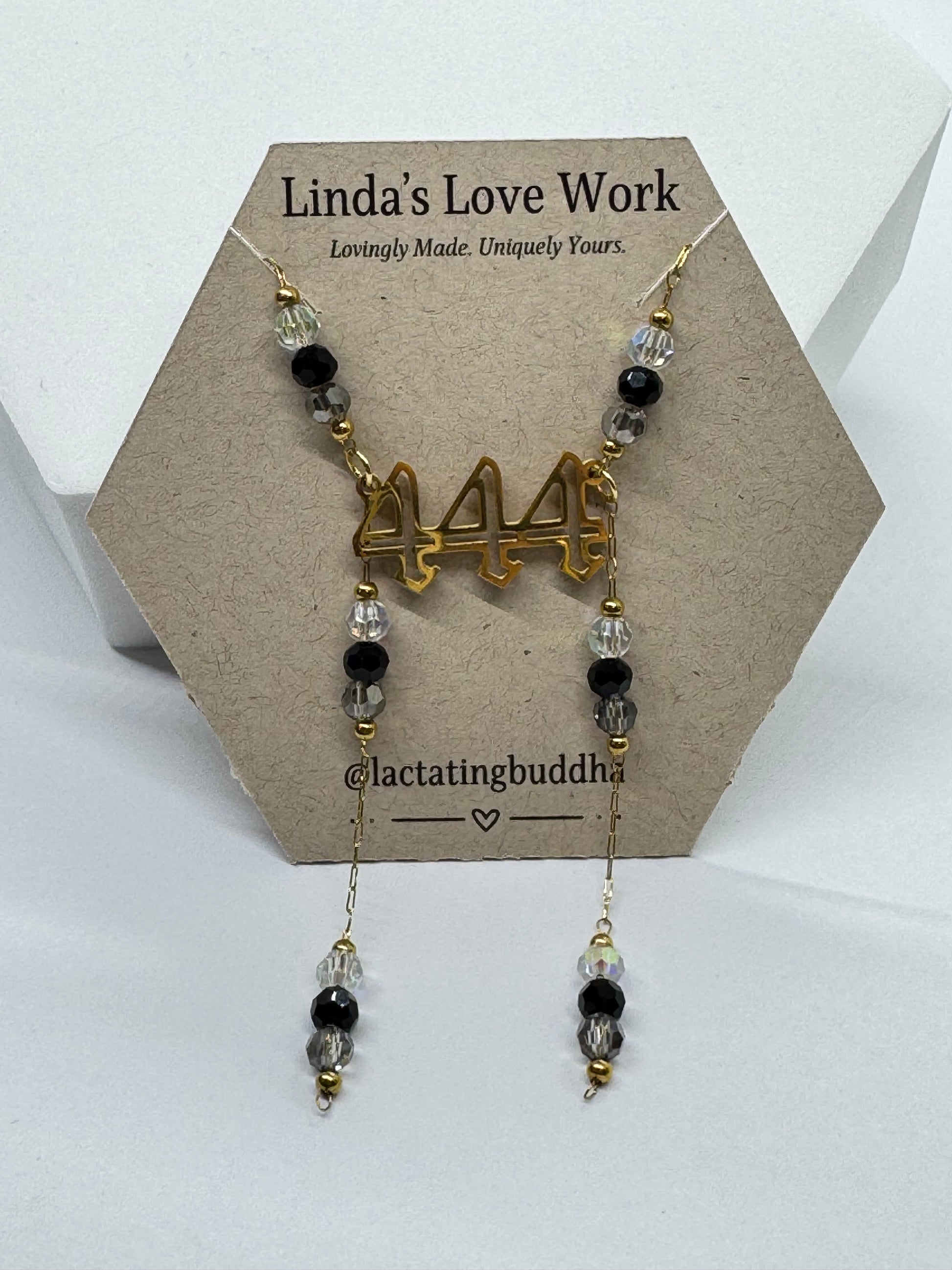 Necklace with beads and gold charm on a branded card