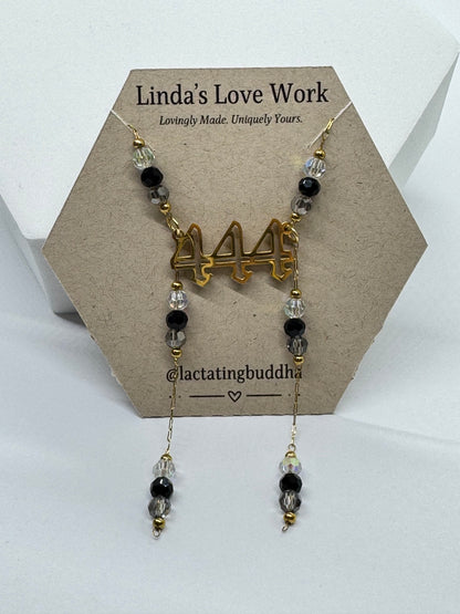 Necklace with beads and gold charm on a branded card