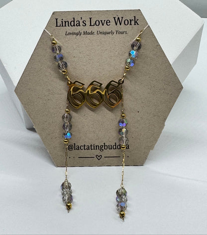 Necklace with '666' pendant and beaded chain on a branded card.