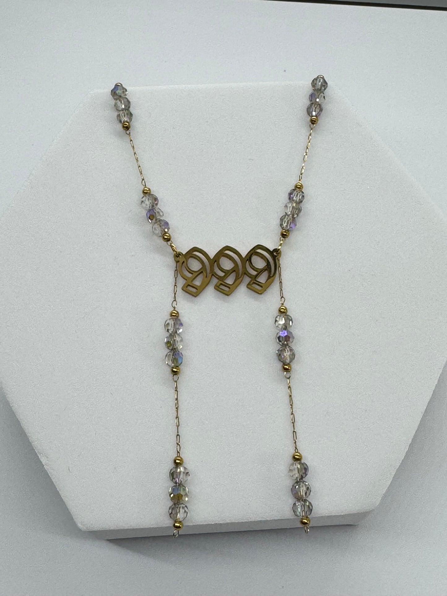 Necklace with beads and gold accents on a white stand