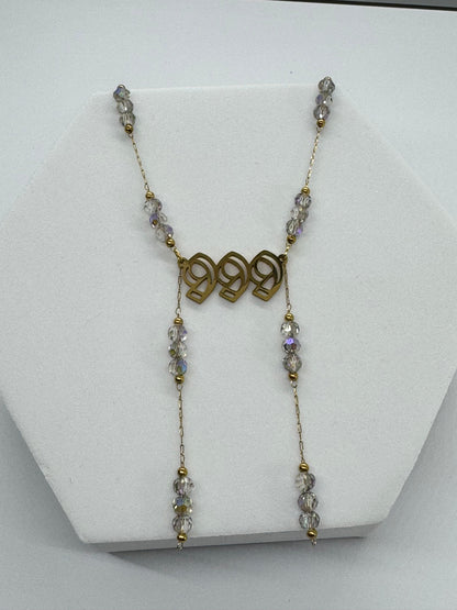 Necklace with beads and gold accents on a white stand