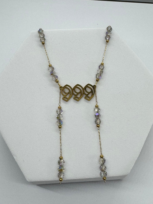 Necklace with beads and gold accents on a white stand