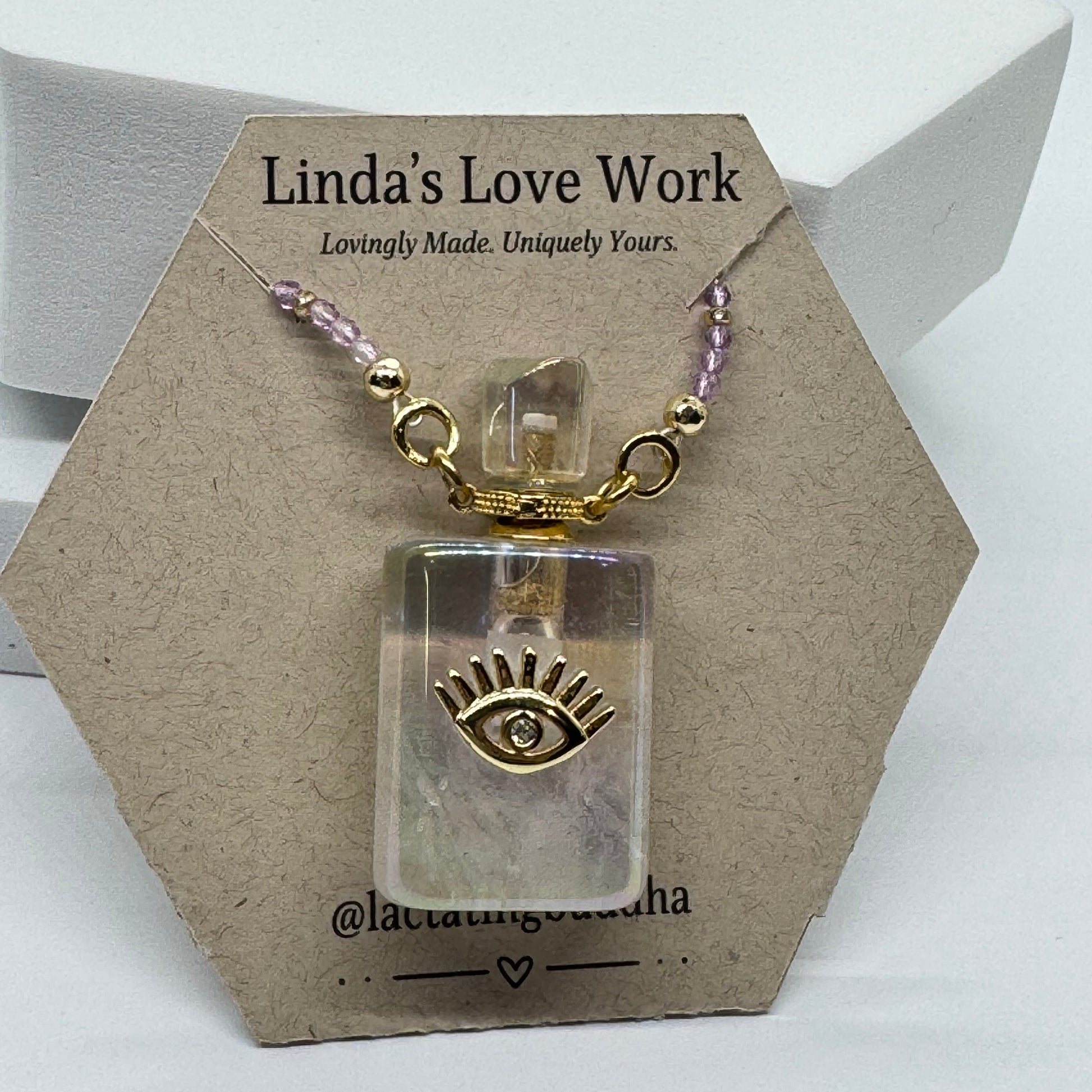 Small clear container with gold and purple accents on a branded card