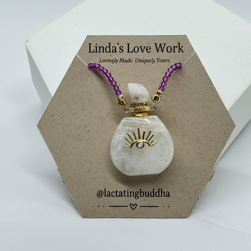 Decorative item with purple beads and gold accents on a hexagonal cardboard stand with 'Linda's Love Work' branding.