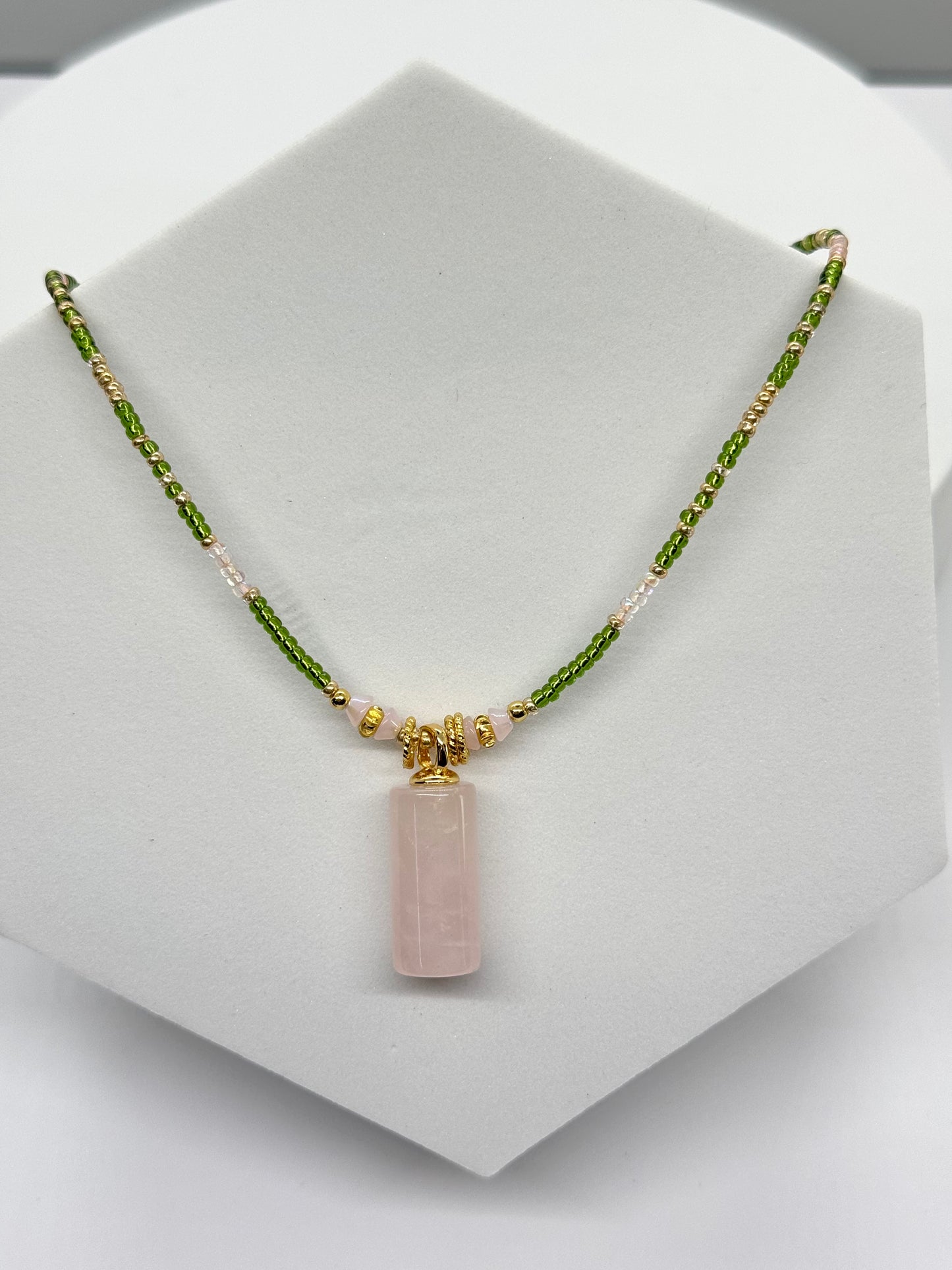 Necklace with a pink pendant on a white stand