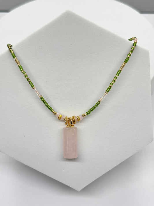 Necklace with a pink pendant on a white stand