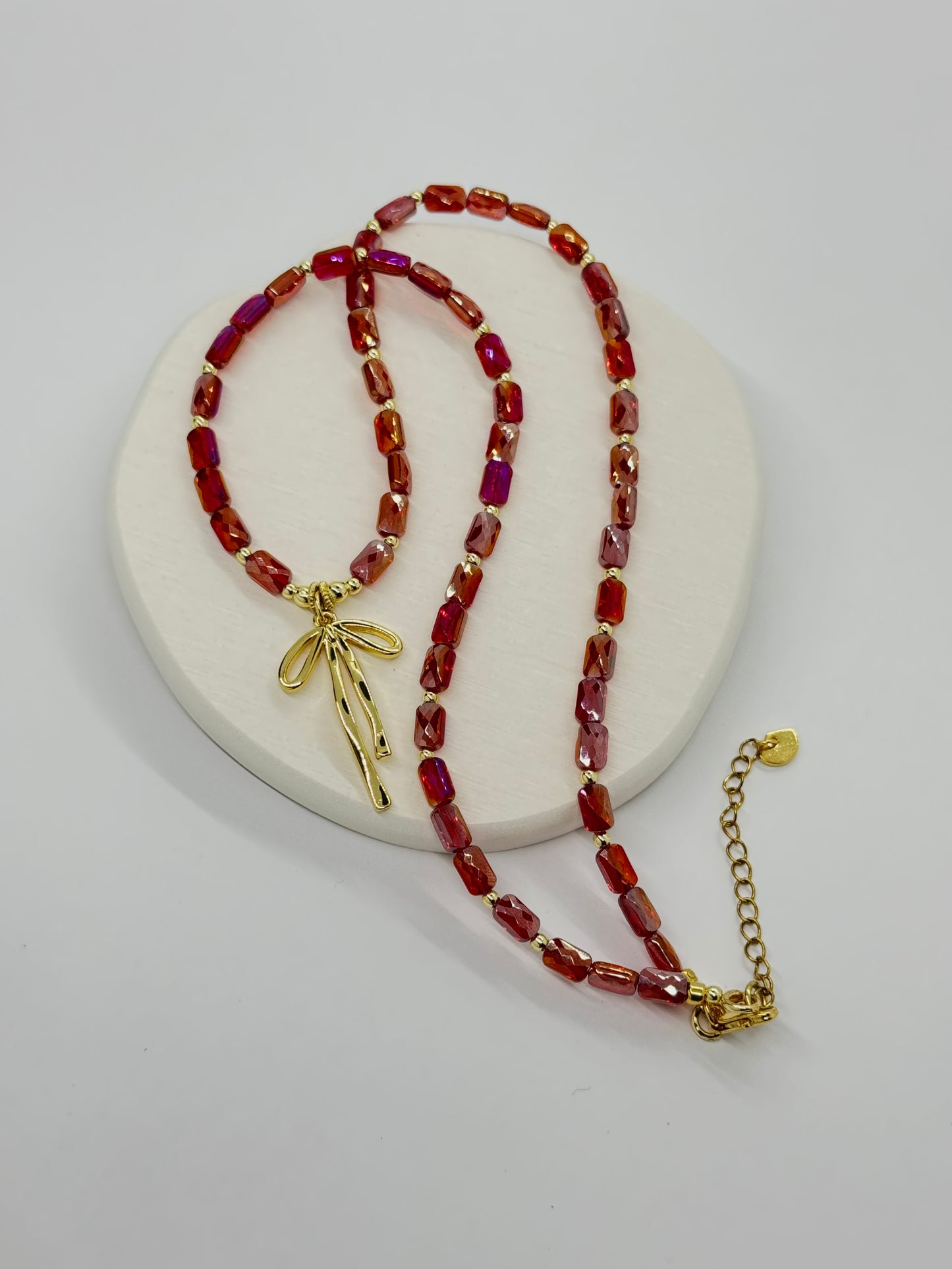 Necklace with red beads and gold accents on a white background