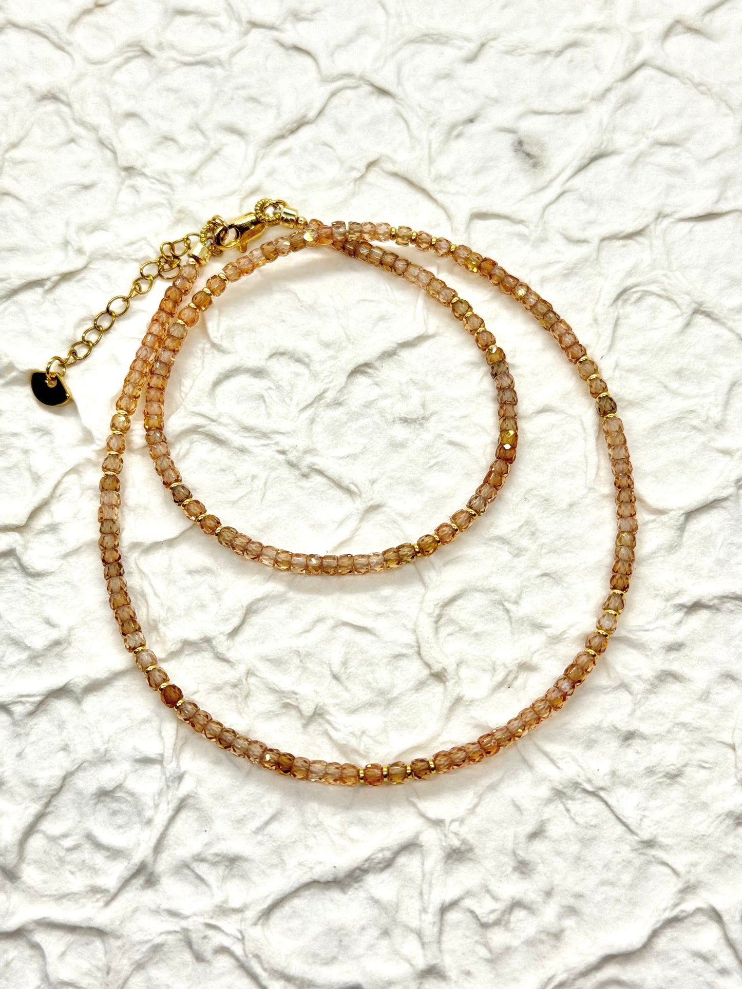 A beaded necklace on a textured white surface
