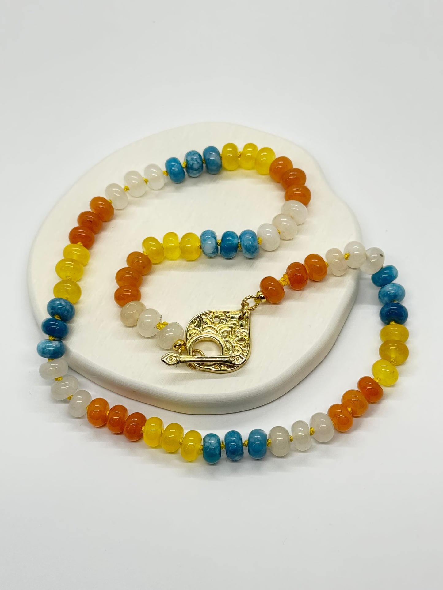 Multicolored beaded necklace with a gold clasp on a white background