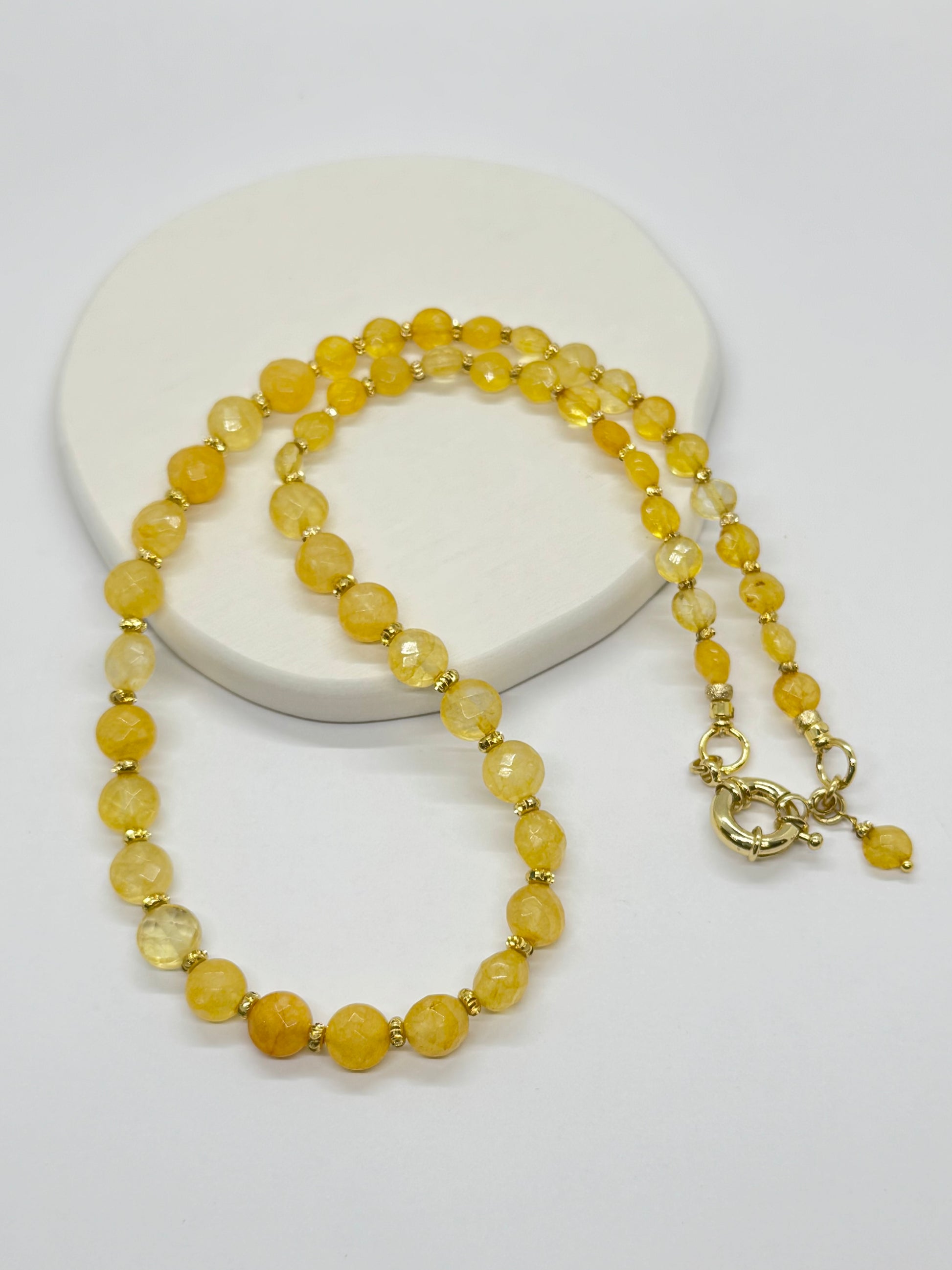 Yellow beaded necklace on a white background
