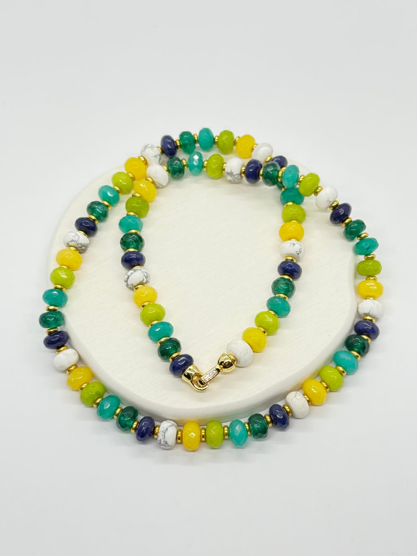 Beaded necklace with multicolor beads on a white stand