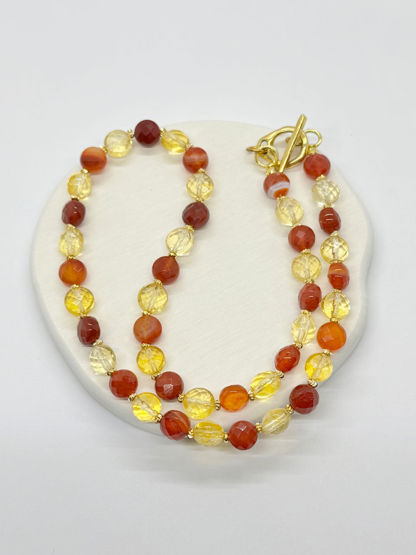Beaded necklace with red and yellow beads on a white background