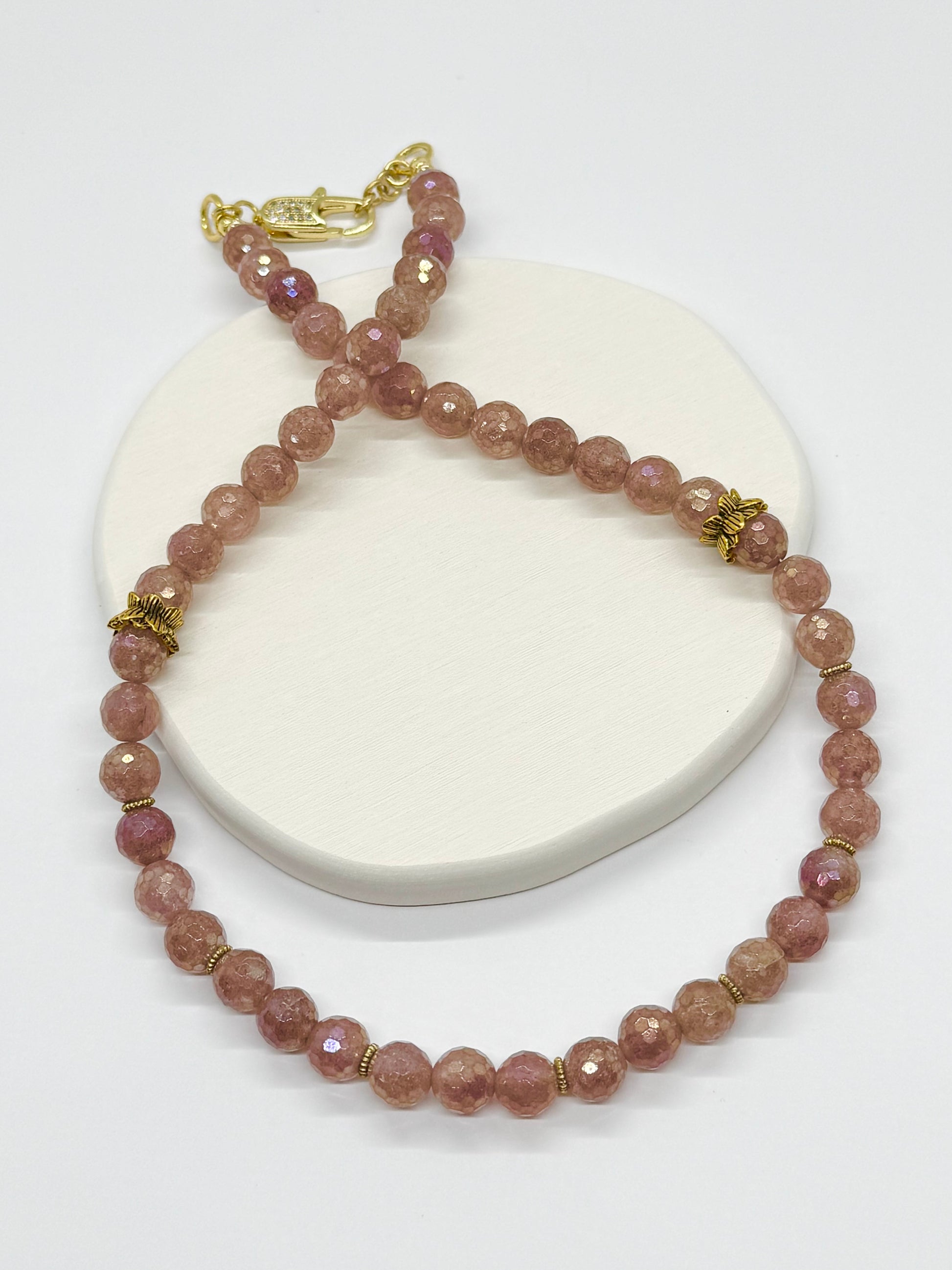 Beaded necklace with gold accents on a white surface