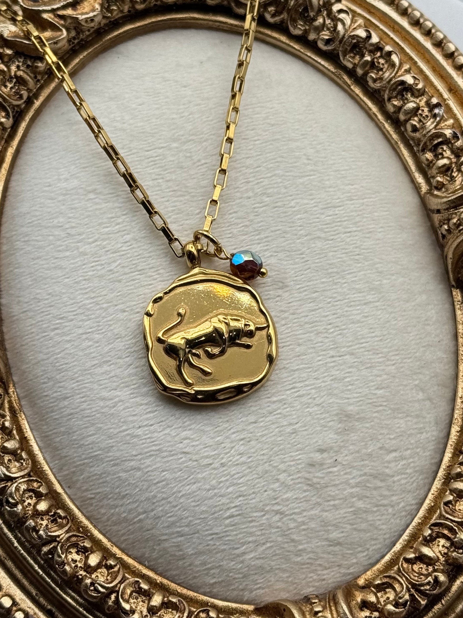 Gold necklace with a pendant in an ornate gold frame