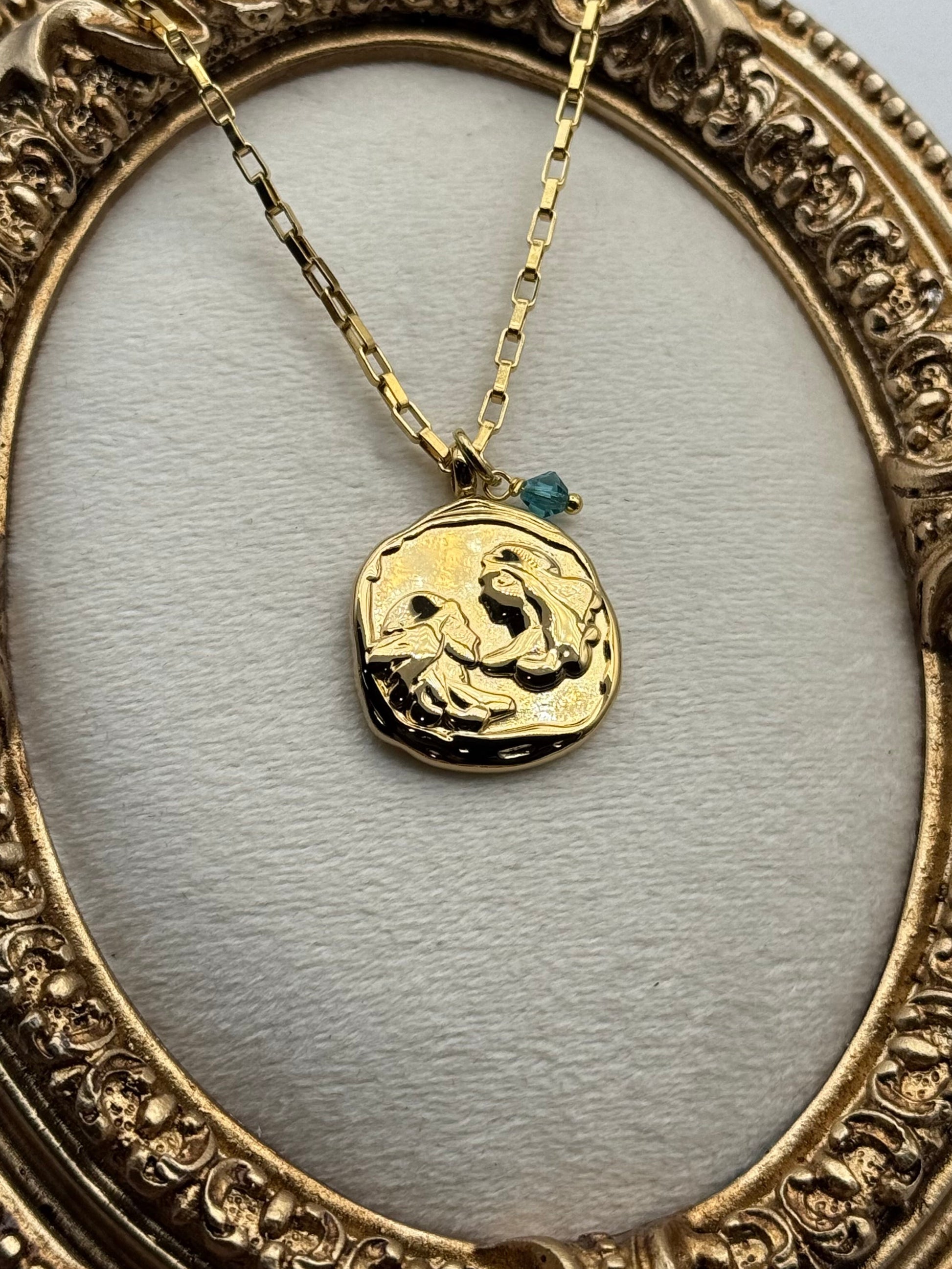 Gold necklace with a pendant in an ornate gold frame