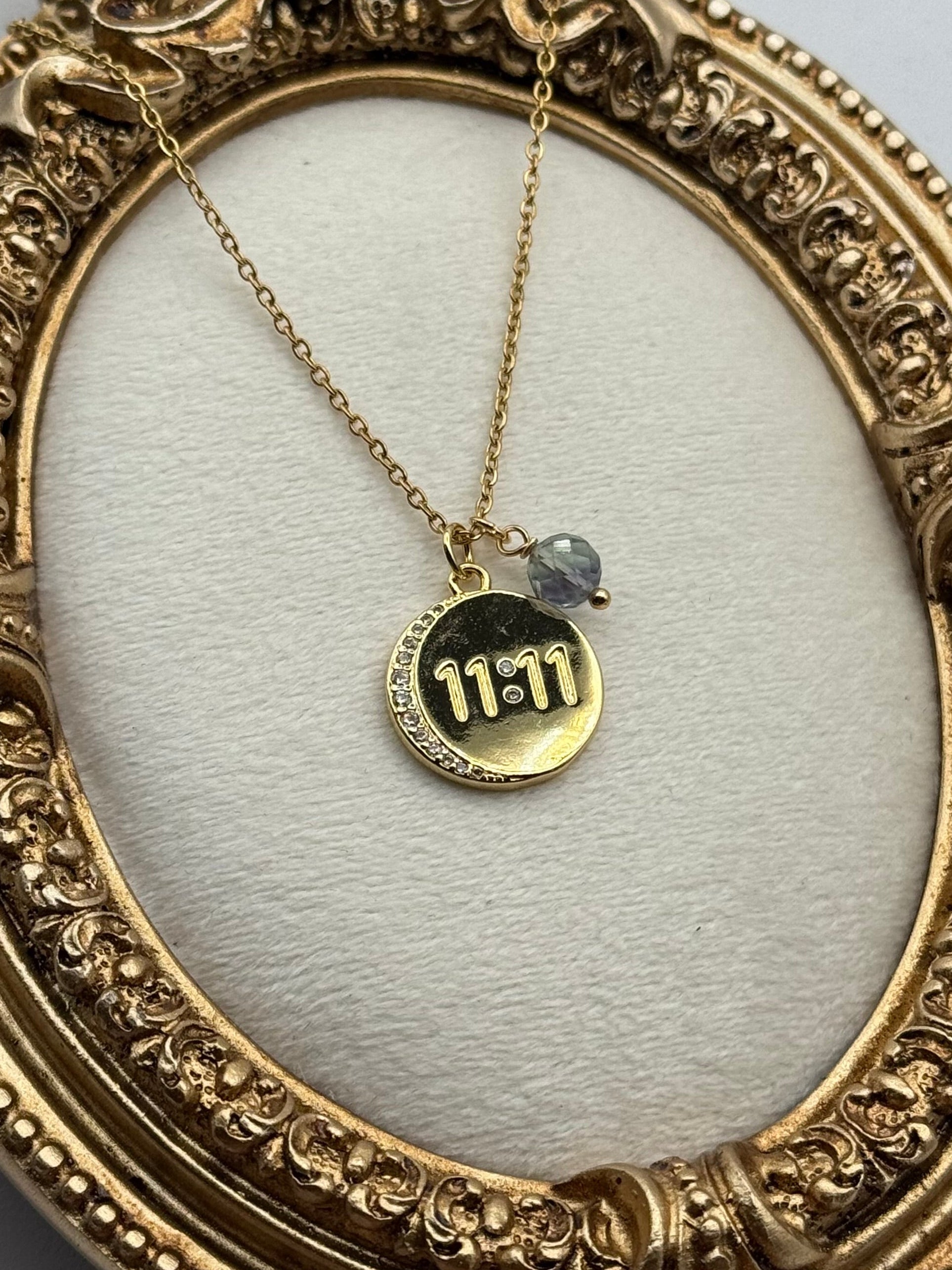 Gold necklace with a pendant featuring '11:11' on a decorative gold frame.