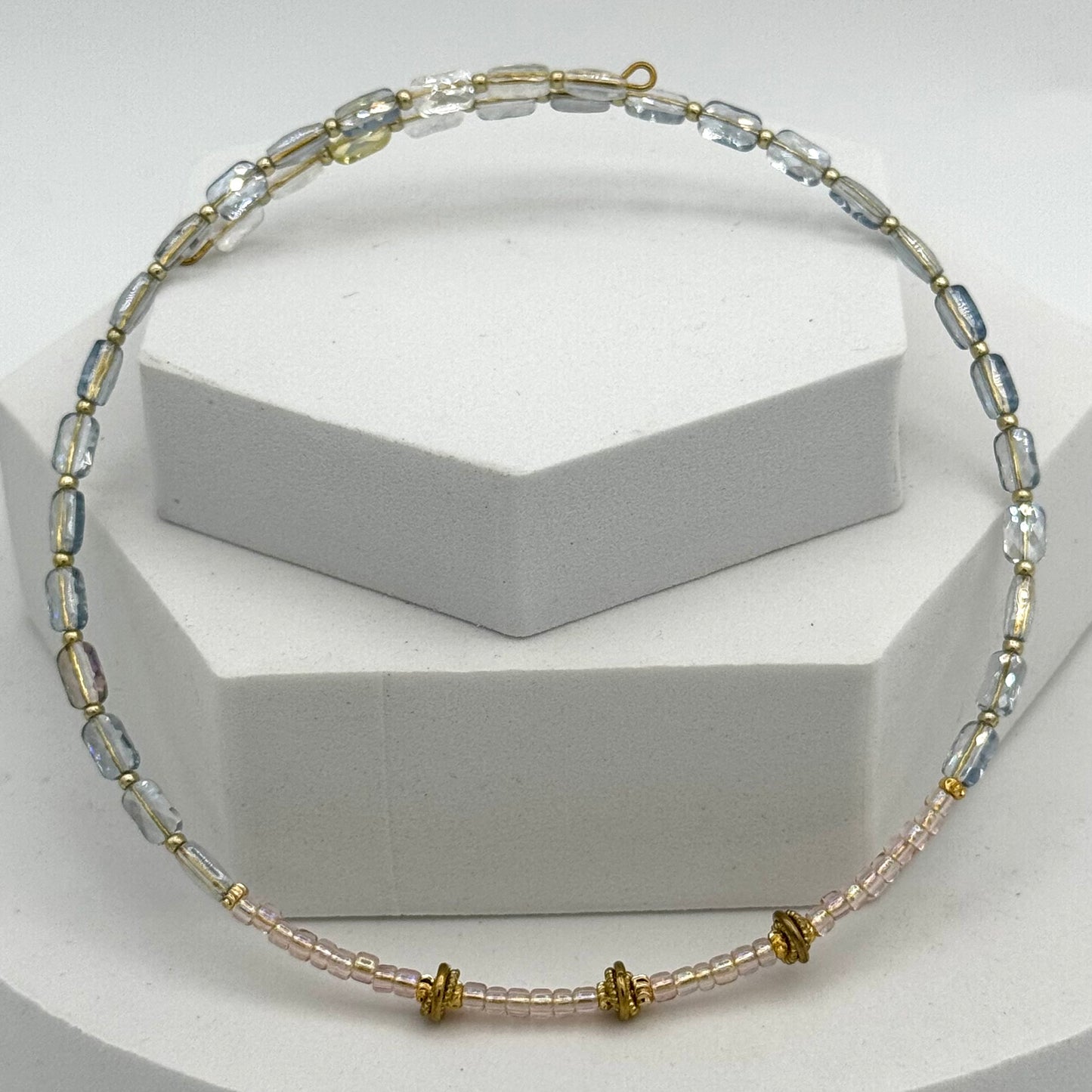 Beaded necklace on a white stand with a neutral background