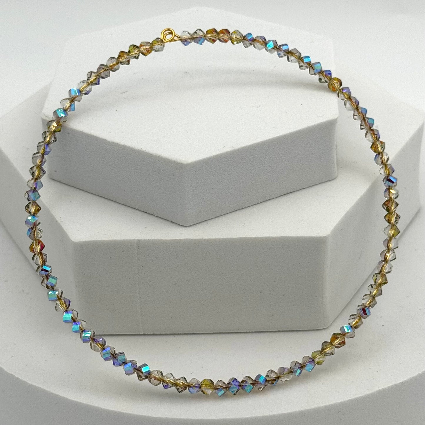 Necklace with multicolored beads on a white stand